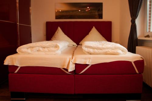 Una cama con dos almohadas encima. en Tag am Meer Sylt, en Westerland