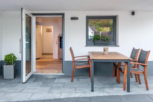 Une table et des chaises en bois sont disponibles sur la terrasse. dans l'établissement Terraluna-Heimbach, à Heimbach