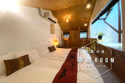 ein Schlafzimmer mit einem Bett in einem Zimmer in der Unterkunft 捉鳳凰 台南百年老宅包棟導覽民宿系列Catchphoenix Centennial Guesthouse in Tainan