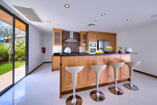 a kitchen with a counter and bar stools at Dhevatara Residence Sea View Villas in Bophut 