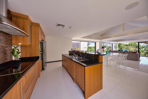 a large kitchen with wooden cabinets and a dining room at Dhevatara Residence Sea View Villas in Bophut 