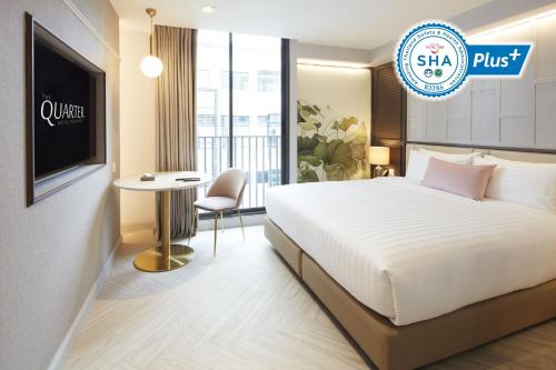 a hotel room with a bed and a table at The Quarter Ploenchit by UHG in Bangkok