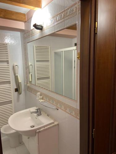 a bathroom with a sink and a mirror at Hotel La Piazzetta in Vidiciatico