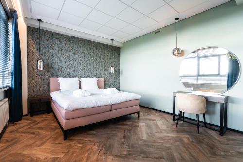 a bedroom with a bed and a table and a chair at Onderwijshotel De Rooi Pannen Eindhoven in Eindhoven