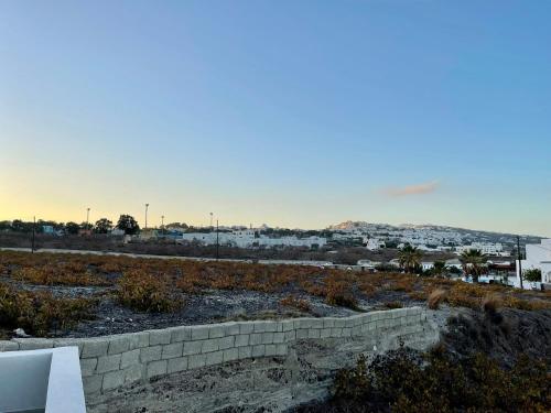a brick wall in a field with a city in the background at Villa Agas in Karterados