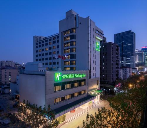 un bâtiment avec un panneau dans une ville dans l'établissement Holiday Inn Shanghai Hongqiao Central, an IHG Hotel, à Shanghai