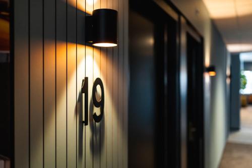 a light on a wall with the number eight on it at Onderwijshotel De Rooi Pannen Eindhoven in Eindhoven