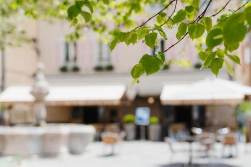 a close up of a building with tables and chairs at Logis - Hotel De La Mairie in Embrun