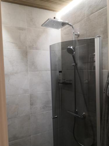 a shower with a glass door in a bathroom at Central Ojakatu in Tampere