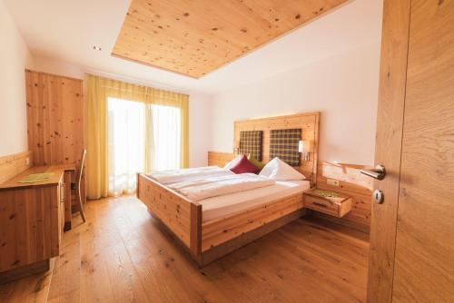 um quarto com uma cama e uma cabeceira em madeira em Thalerhof Appartement Christoph em Verano