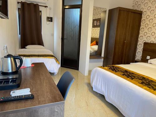 um quarto de hotel com duas camas e uma secretária com um computador em Welcome Inn em Grand Baie