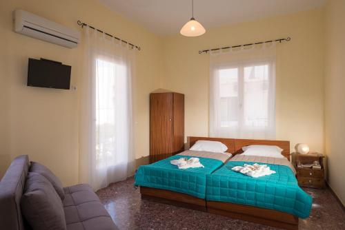 a bedroom with a bed and a couch and a tv at Penelopi Rooms in Chania Town