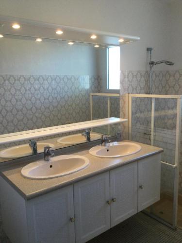 une salle de bain avec deux lavabos et un grand miroir dans l'établissement Maison pour 4 - Jardin - 400m plage des Lutins, à Noirmoutier-en-l'lle