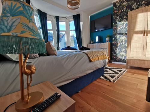 a bedroom with a bed and a table with a lamp at Flamingo Lodge in Torquay