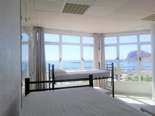 um quarto com 2 camas e uma grande janela em Albergue Club Náutico de Águilas em Águilas