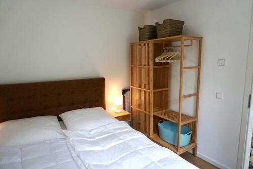 ein Schlafzimmer mit einem weißen Bett und einem Bücherregal in der Unterkunft Strandglück in Scharbeutz