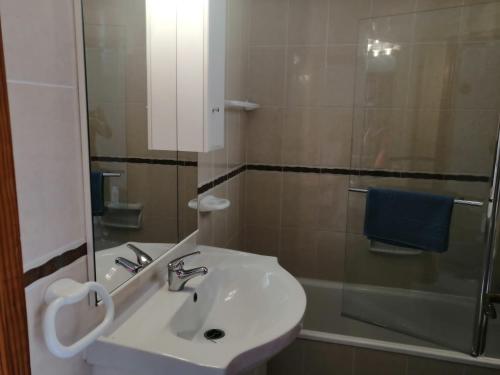 ein weißes Bad mit einem Waschbecken und einer Dusche in der Unterkunft 1 Bedroom Apartment with stunning sea view in Arona