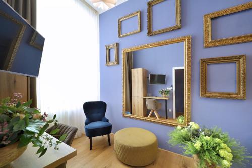 a living room with a mirror and a chair at Kalina Apartments in Brno