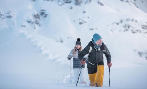a man and a woman on skis in the snow at Hotel Alpenblick in Sesto