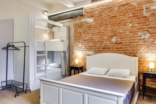 um quarto com uma cama e uma parede de tijolos em Nabokov Loft-Hotel em Rostov on Don