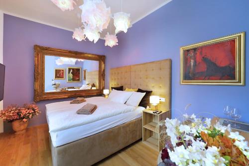 a bedroom with a bed with a mirror and purple walls at Kalina Apartments in Brno