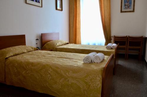 two beds in a hotel room with towels on them at Dom Polski Jana Pawła II - Casa per ferie in Rome