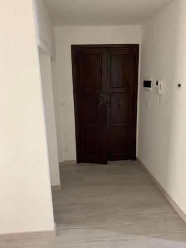 einen leeren Flur mit einer Holztür in einem Zimmer in der Unterkunft Casa Sigiu - La Piazza in Rieti