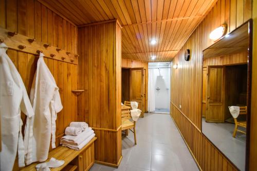 baño con paredes de madera y pasillo con toallas en METROPOL HOTEL Yerevan en Ereván