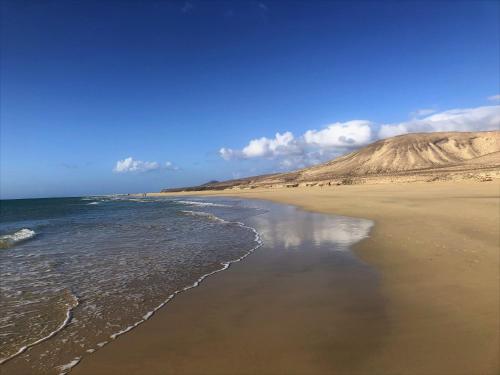 una vista de la playa con una montaña en el fondo en Jardin de Costa Calma, en Costa Calma