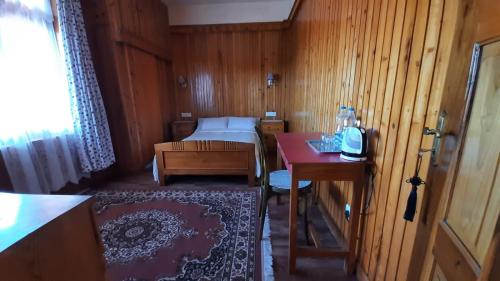 Kleines Zimmer mit einem Bett und einem Tisch in der Unterkunft SEWANS PLACE Homestay in Mirik