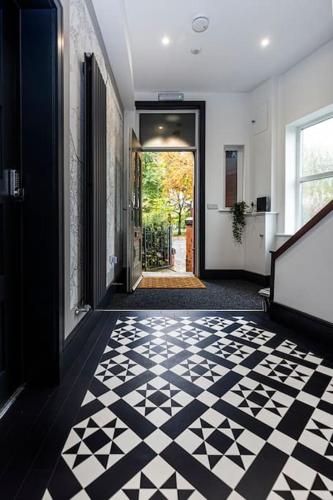 a hallway with a black and white checkered floor at BOOTique House - Luxury Group Accommodation in Wakefield in Wakefield