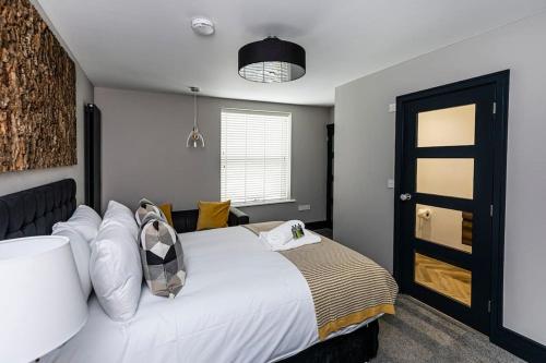 a bedroom with a large white bed and a window at BOOTique House - Luxury Group Accommodation in Wakefield in Wakefield