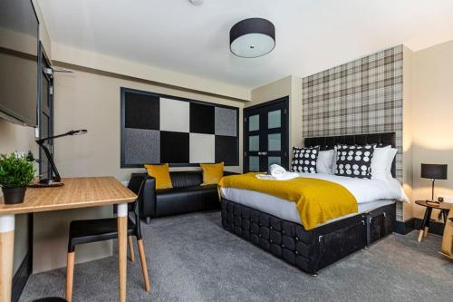 a bedroom with a bed and a couch and a table at BOOTique House - Luxury Group Accommodation in Wakefield in Wakefield