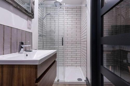 a bathroom with a sink and a shower at BOOTique House - Luxury Group Accommodation in Wakefield in Wakefield