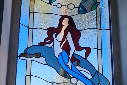 a stained glass window of a woman in the water at Villa del Mar in Mazotos