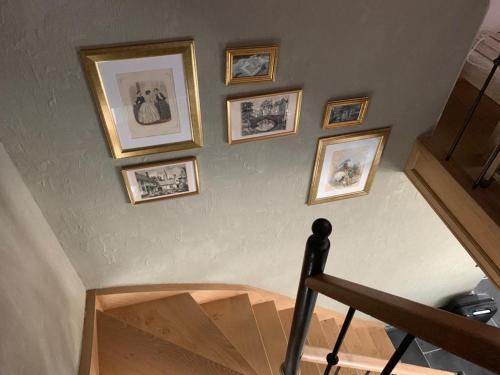 a staircase with framed pictures on the wall at Guestsuite Sir Joachim Bruges in Bruges