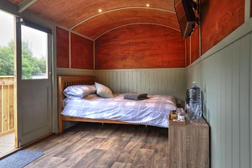 a bedroom with a bed with a wooden ceiling at The Windmill Inn - Whitby in Whitby