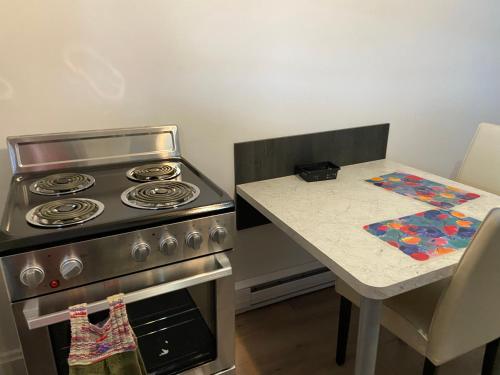 cocina con fogones y mesa pequeña en Gestion clin d’oeil - 505, en La Tuque