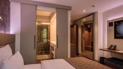 a bedroom with a bed and a sliding glass door at Innspire Hotel in Munich