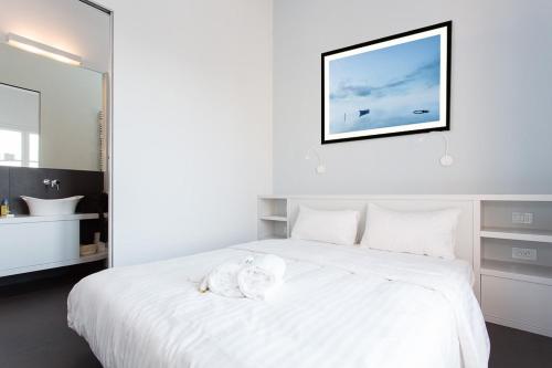 un lit blanc avec un animal rembourré au dessus dans l'établissement Top floor2 beds w/sea wiew, à Cannes