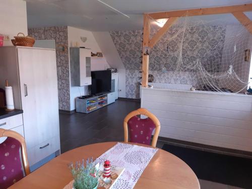 a kitchen and dining room with a table and chairs at Helgas Ferienwohnung 4 Sterne in Südbrookmerland