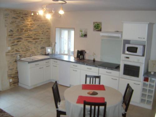 une cuisine avec une table et une salle à manger dans l'établissement Gîte des Forges, à Saint Lo