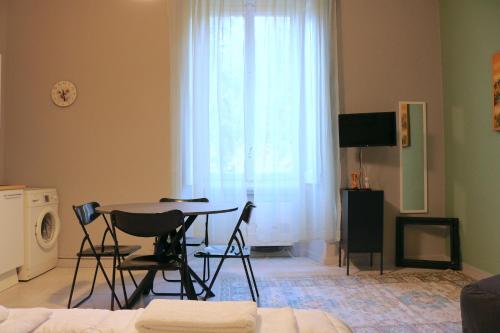 a living room with a table and chairs and a window at Washington Suite in Milan