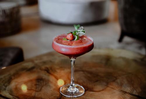 a strawberry drink in a wine glass on a wooden table at Hanza Pałac Wellness & SPA in Warlubie