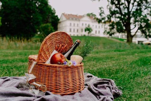 a basket of fruit sitting on a blanket on the grass at Hanza Pałac Wellness & SPA in Warlubie