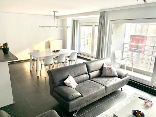 - un salon avec un canapé et une table dans l'établissement Vakantieappartement Emiel Centrum Oostende, à Ostende