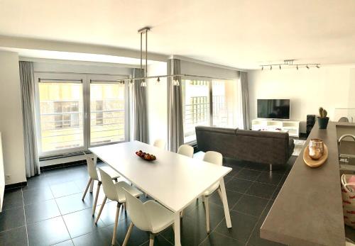 a living room with a white table and chairs at Vakantieappartement Emiel Centrum Oostende met garage in Ostend