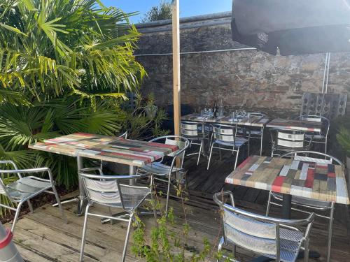 un groupe de tables et de chaises sur une terrasse dans l'établissement Hotel Les Voyageurs, à Les Sables-dʼOlonne