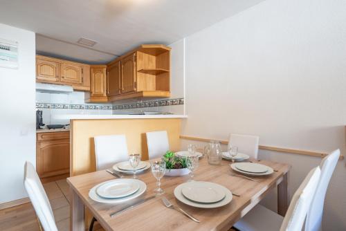 a kitchen with a table, chairs, and a table cloth at Apartamentos Pie de Pistas 3000 in Pas de la Casa