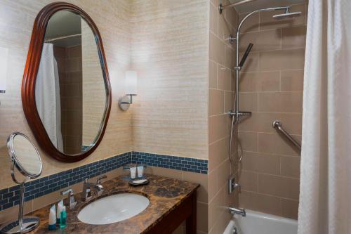 een badkamer met een wastafel, een douche en een spiegel bij The Westin Mount Laurel in Mount Laurel